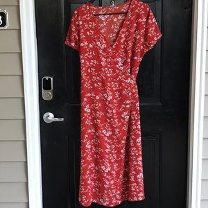 A beautiful rust color light weight dress with a cream colored floral pattern.